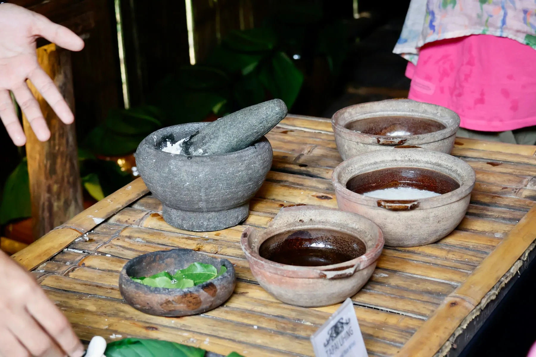 A stone mortar and clay bowls of freshly prepared herbal pastes